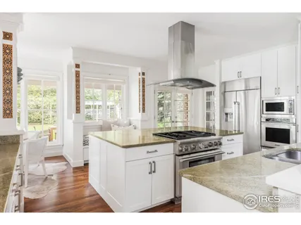 a kitchen with stainless steel appliances granite countertop a stove and white cabinets