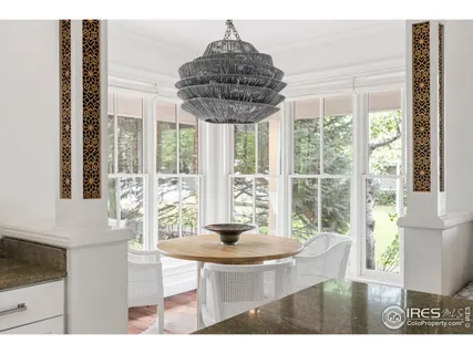 a dining room with furniture and large windows