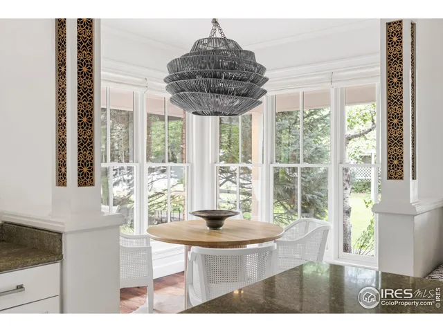 a dining room with furniture and large windows