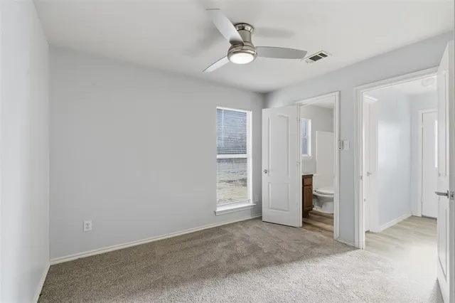 an empty room with a ceiling fan and closet