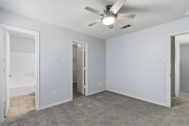 an empty room with a ceiling fan and a window