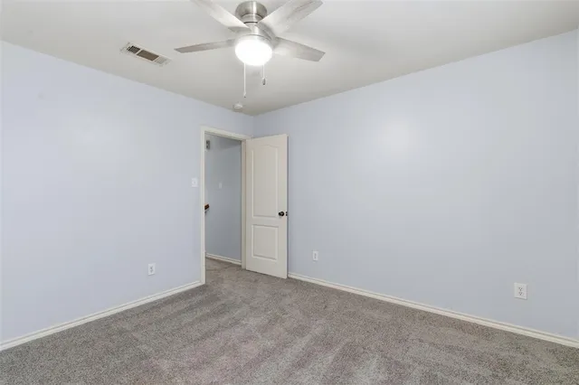 an empty room with a fan and a fan