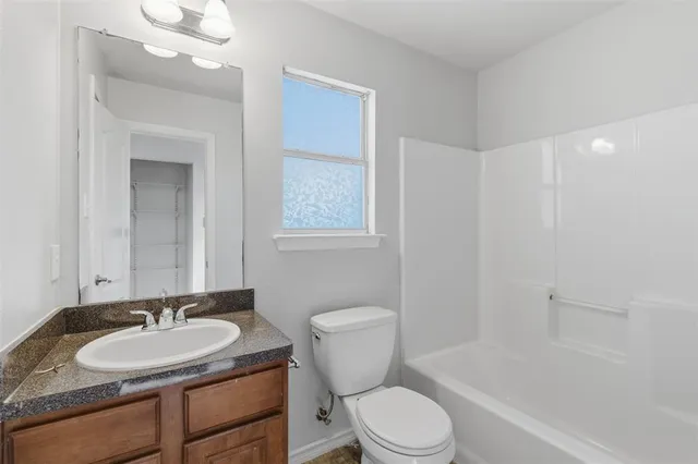 a bathroom with a granite countertop toilet a sink and a bathtub