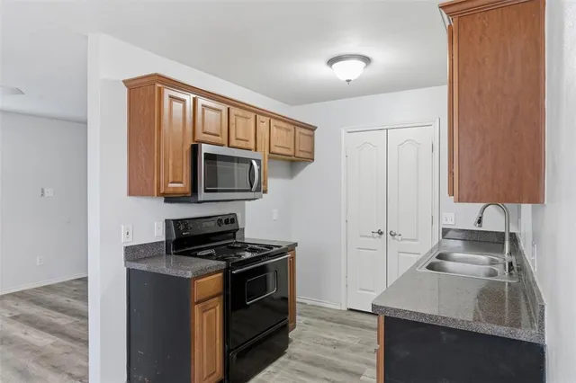 a kitchen with stainless steel appliances granite countertop a sink stove and microwave
