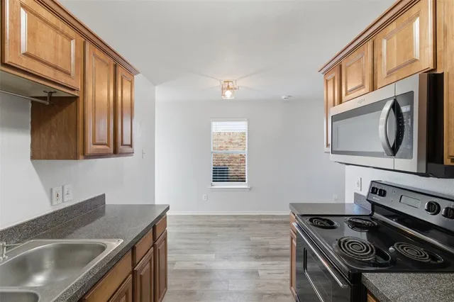 a kitchen with stainless steel appliances granite countertop a sink stove and cabinets