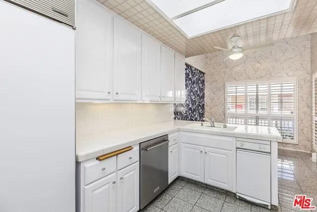 a kitchen with white cabinets and white appliances