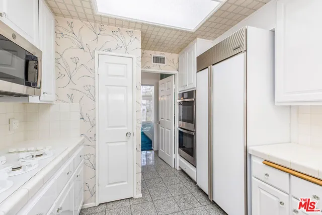 a kitchen with stainless steel appliances a refrigerator and a cabinets