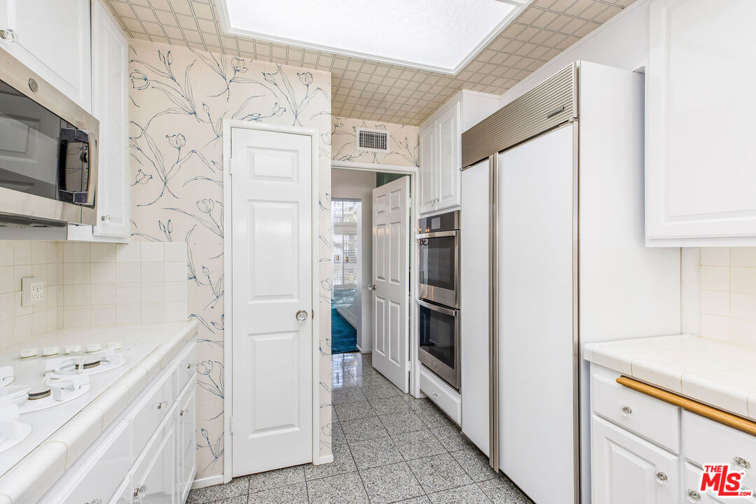 4342 Redwood Avenue, Unit C307 Marina del Rey, CA 90292 - Photo 13 of 48 a kitchen with stainless steel appliances a refrigerator and a cabinets