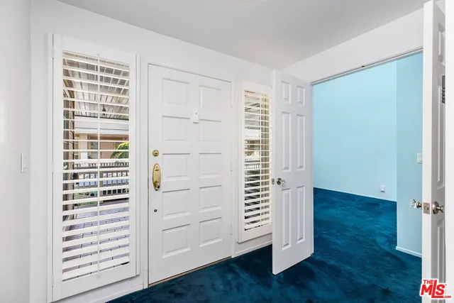 an empty room with wooden floor closet and windows