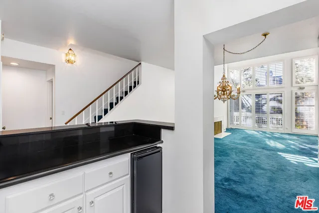 a kitchen with granite countertop white cabinets and black appliances