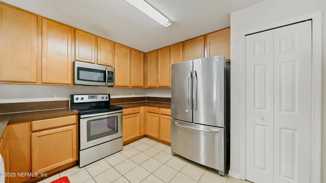 a kitchen with stainless steel appliances granite countertop a refrigerator stove microwave and sink