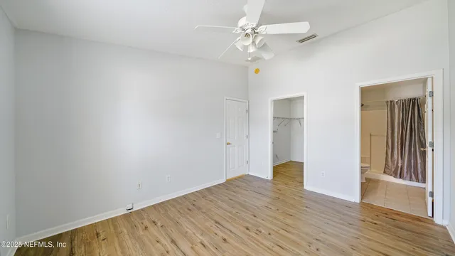 a view of a room with wooden floor and ceiling fan
