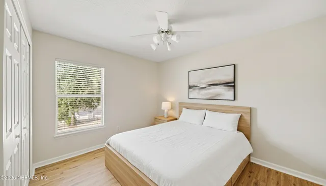 a bedroom with a large bed and a chandelier