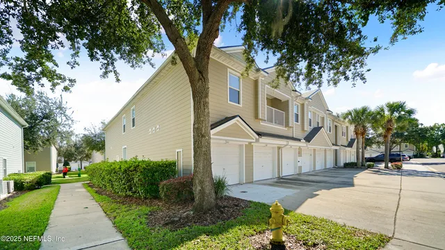 a front view of a house with a yard and trees
