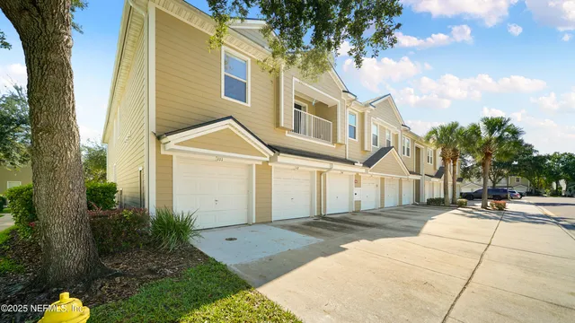 a view of a white building among the street with palm trees