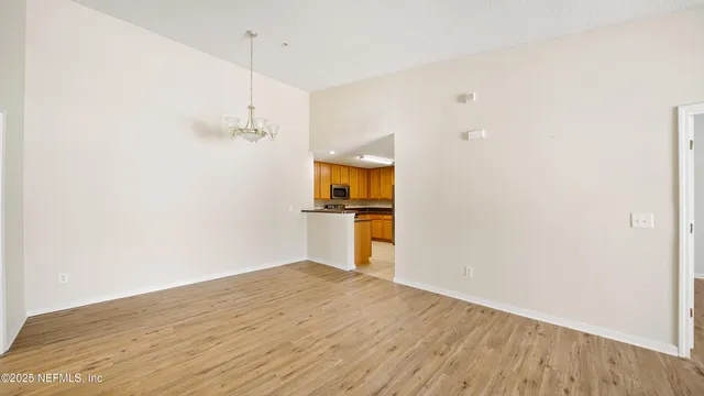 a view of a kitchen with wooden floor and a ceiling fan
