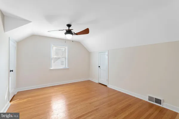 a view of a room with wooden floor and a ceiling fan