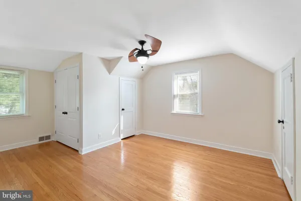 a view of a room with wooden floor and ceiling fan