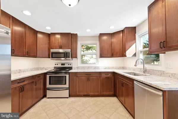 a kitchen with stainless steel appliances granite countertop wooden cabinets a sink and dishwasher