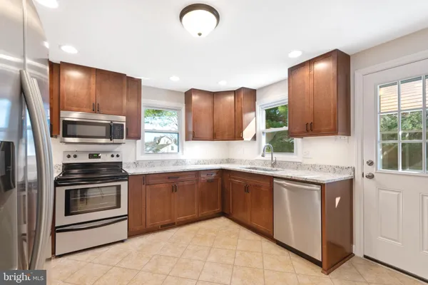 a kitchen with stainless steel appliances granite countertop a sink and stove top oven