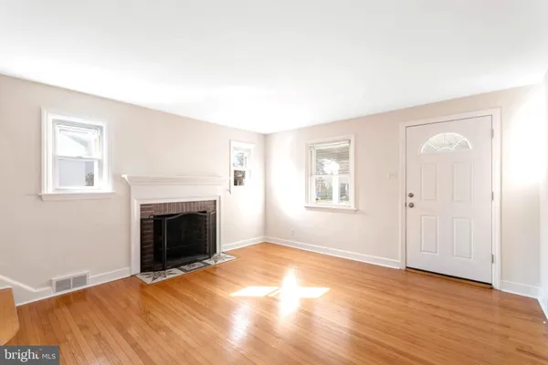 an empty room with windows and fireplace