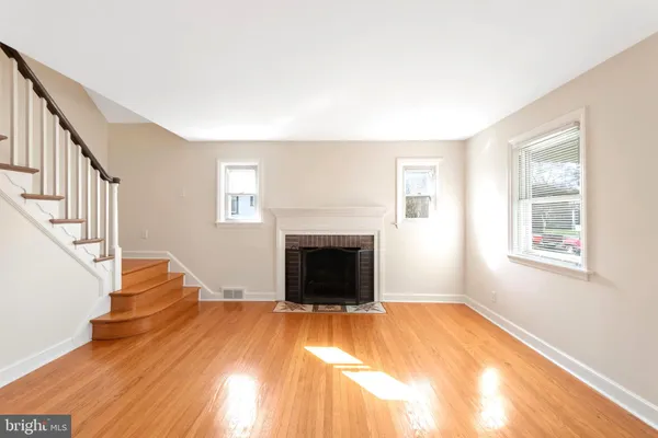 a view of a livingroom with wooden floor and a fireplace