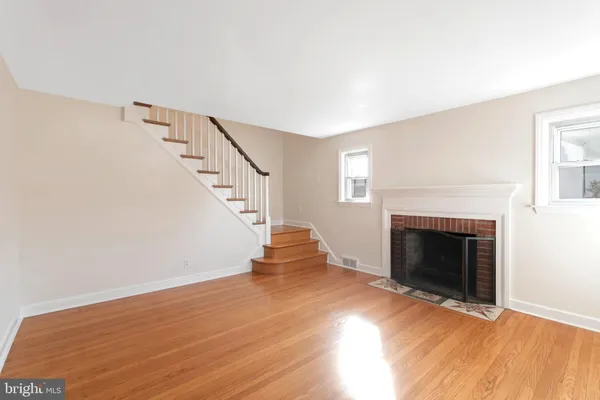 a view of a livingroom with wooden floor and a fireplace