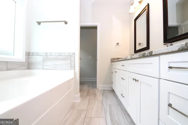 a spacious bathroom with a bathtub and a sink