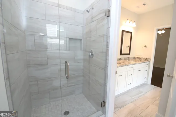 a bathroom with a shower sink and mirror