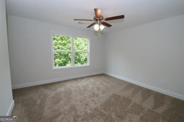 an empty room with a window and a fan