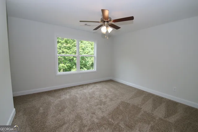 an empty room with a window and a fan