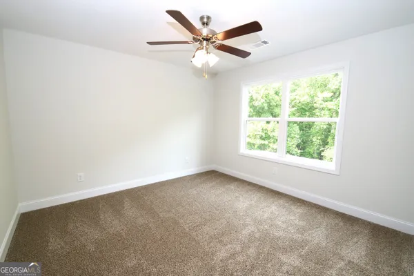 an empty room with a window and a ceiling fan