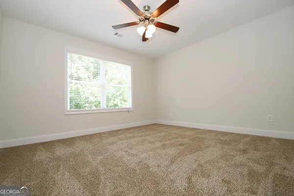 an empty room with a window and a fan