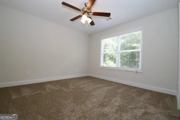 an empty room with a window and a fan