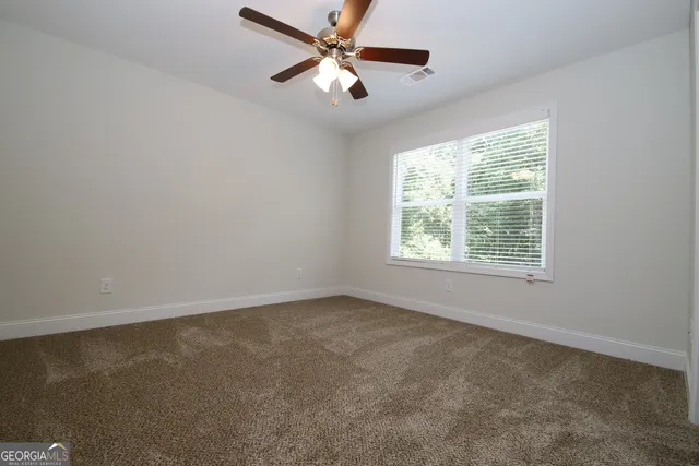 an empty room with a window and a fan