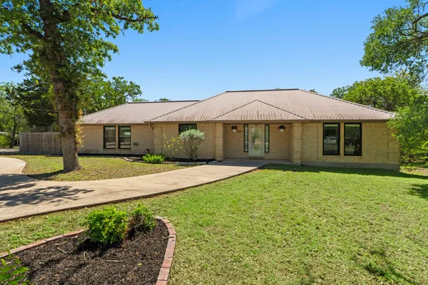 a house with green field in front of it