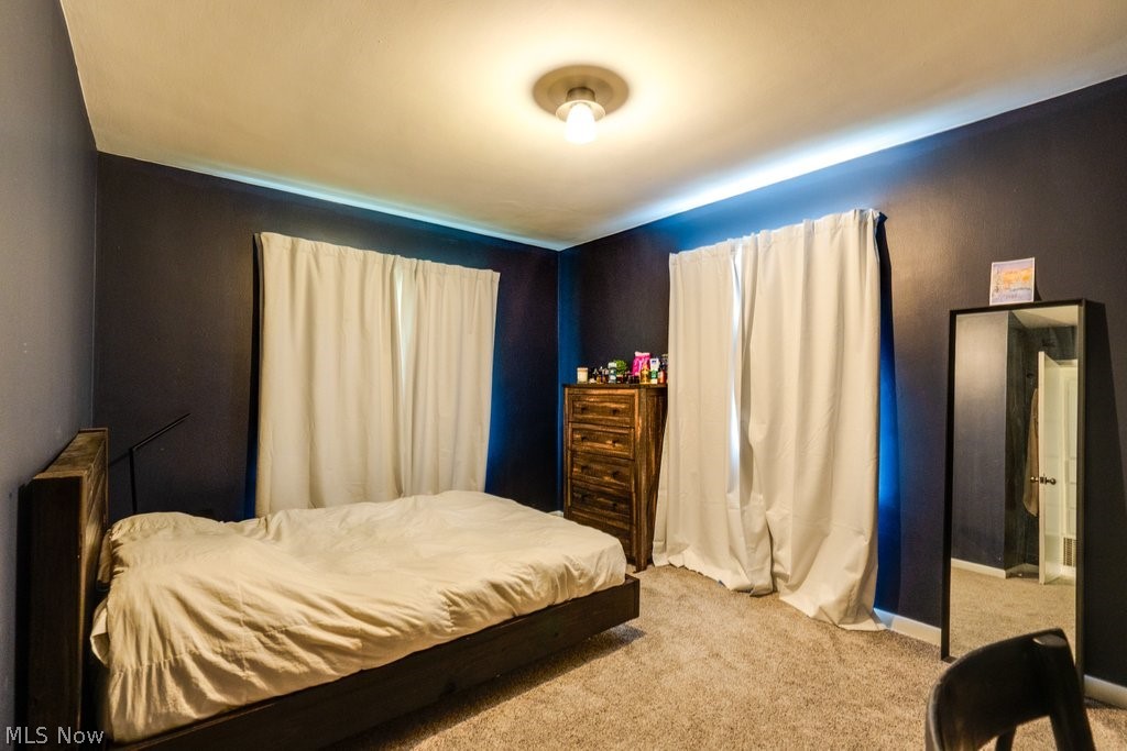 3569 Elm Road Stow, OH 44224 - Photo 10 of 17 Carpeted bedroom with dark blue walls, a ceiling-mounted light fixture, and two window openings with white drapes