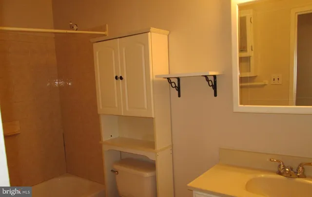 a bathroom with a granite countertop mirror sink and vanity