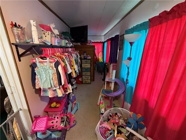 a view of a bed with clothes and shoes