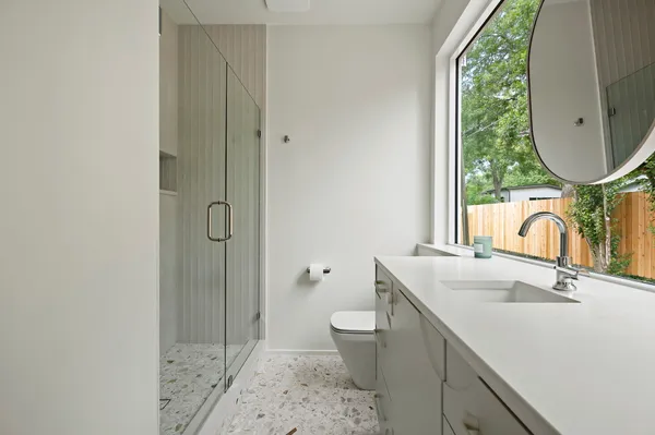 a bathroom with a sink toilet and shower a mirror