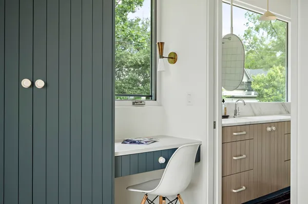 a bathroom with a granite countertop sink toilet and large window
