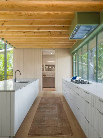 a large kitchen with kitchen island a stove a sink a refrigerator white cabinets and wooden floor