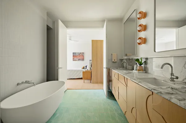 a spacious bathroom with a granite countertop sink mirror and bathtub