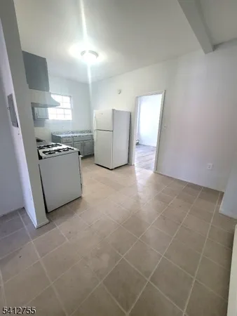 a kitchen with granite countertop a refrigerator and a stove