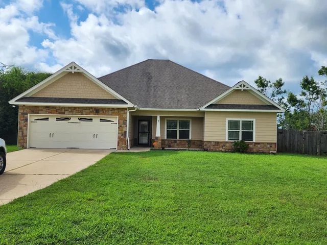 a front view of a house with a yard and garage