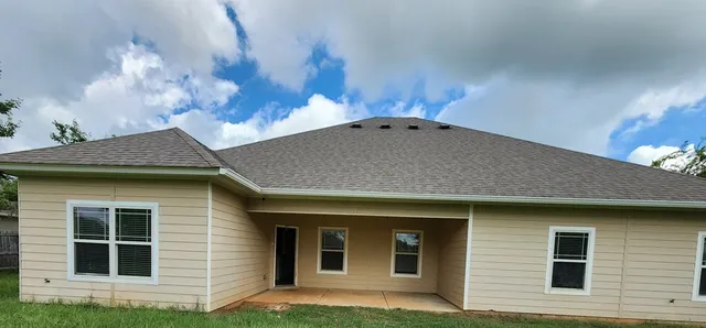 a backyard of a house with table and chairs