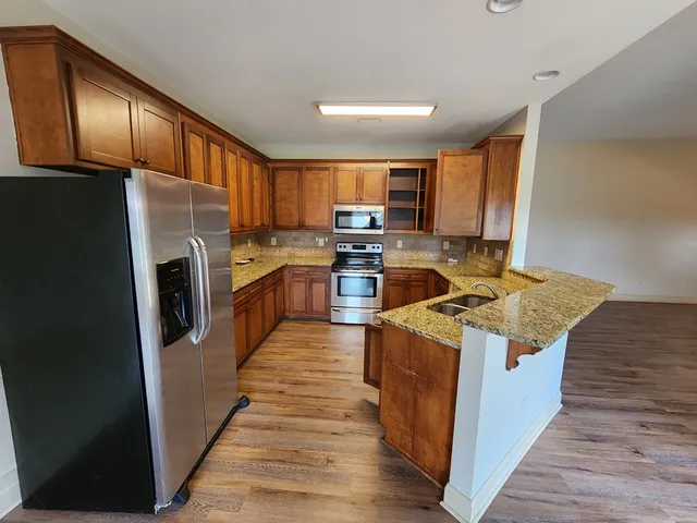 a kitchen with stainless steel appliances granite countertop a refrigerator stove and oven
