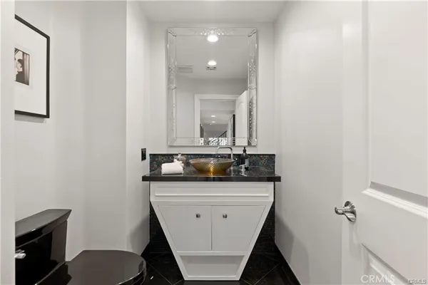 a bathroom with a granite countertop sink a mirror and vanity