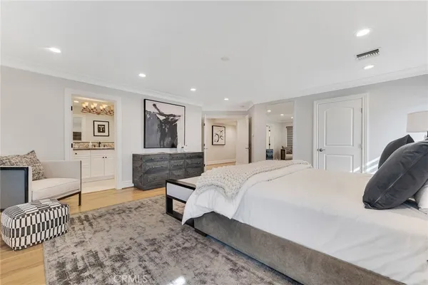 a spacious bedroom with a bed a couch and dresser