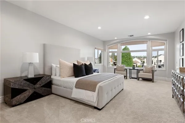 a spacious bedroom with a bed and a large window